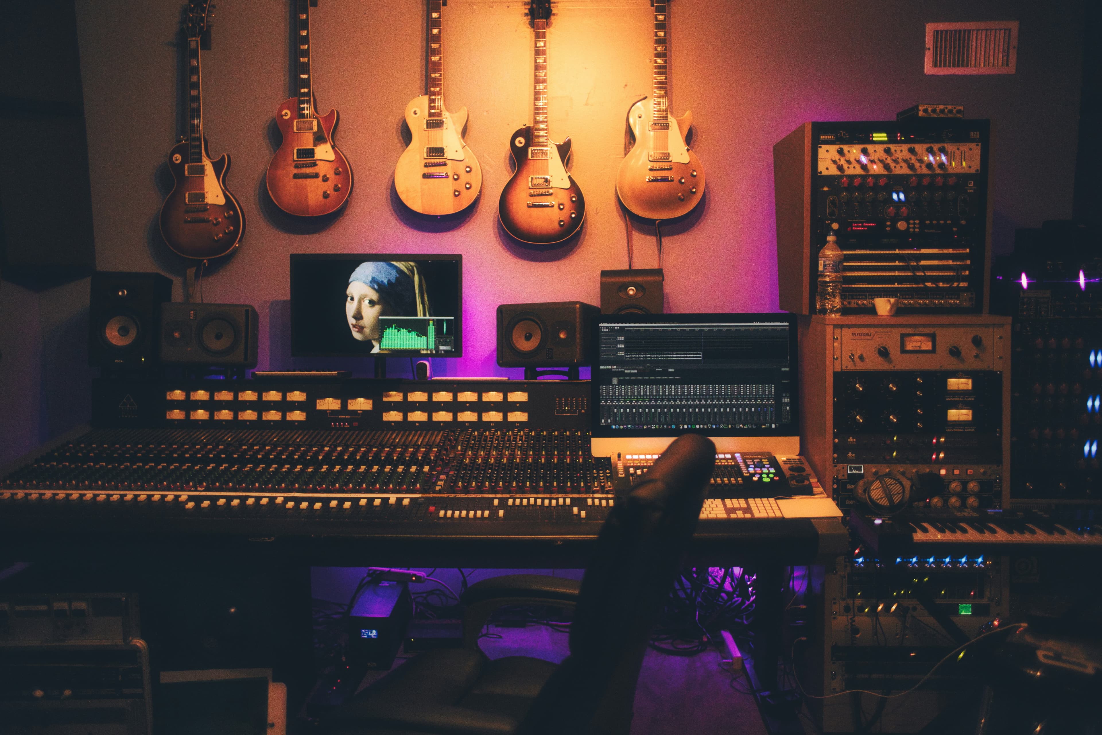 A creator working in a professional recording studio with warm lighting, microphones and production equipment.