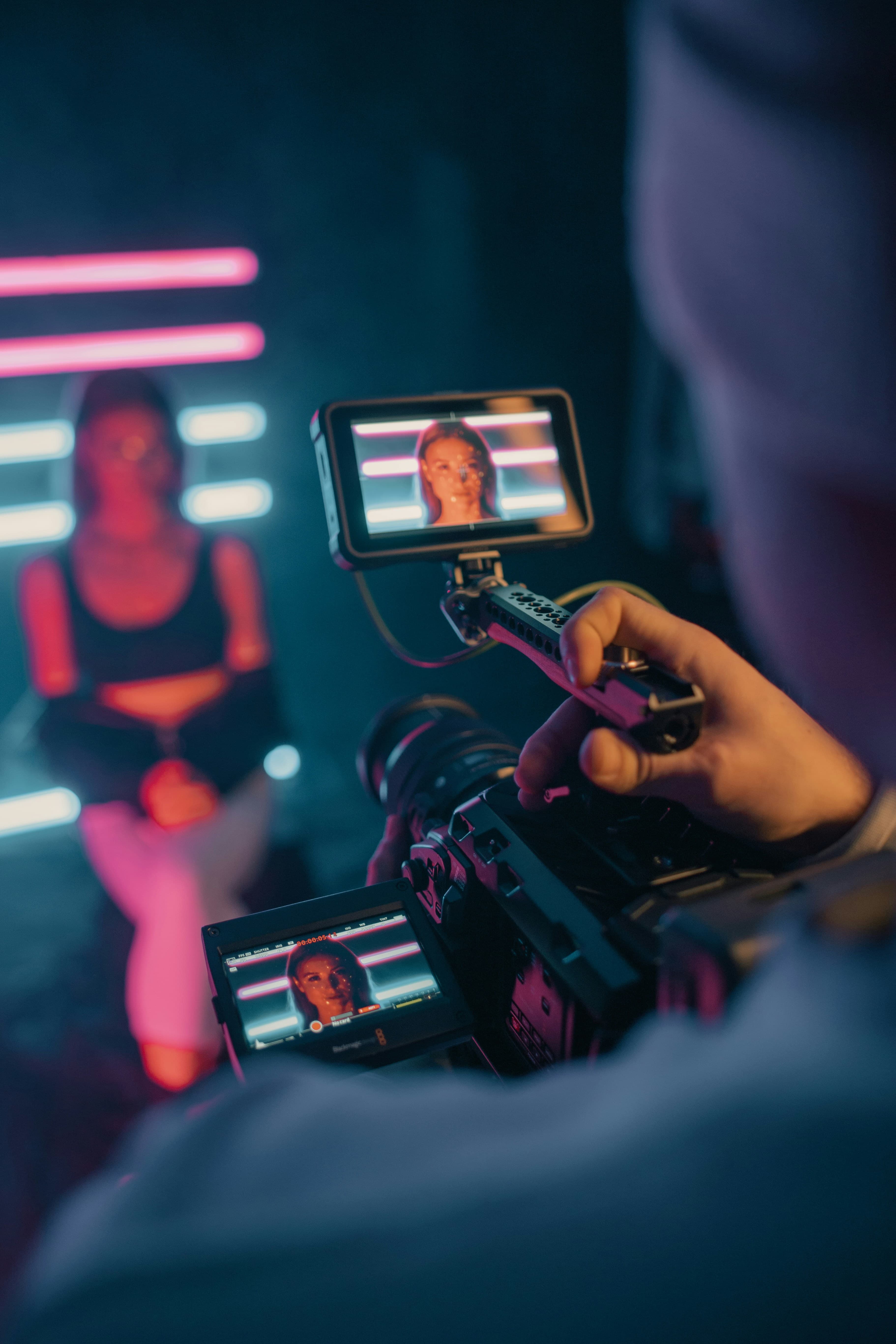 Creators collaborating while one films another with a smartphone in a creator environment.