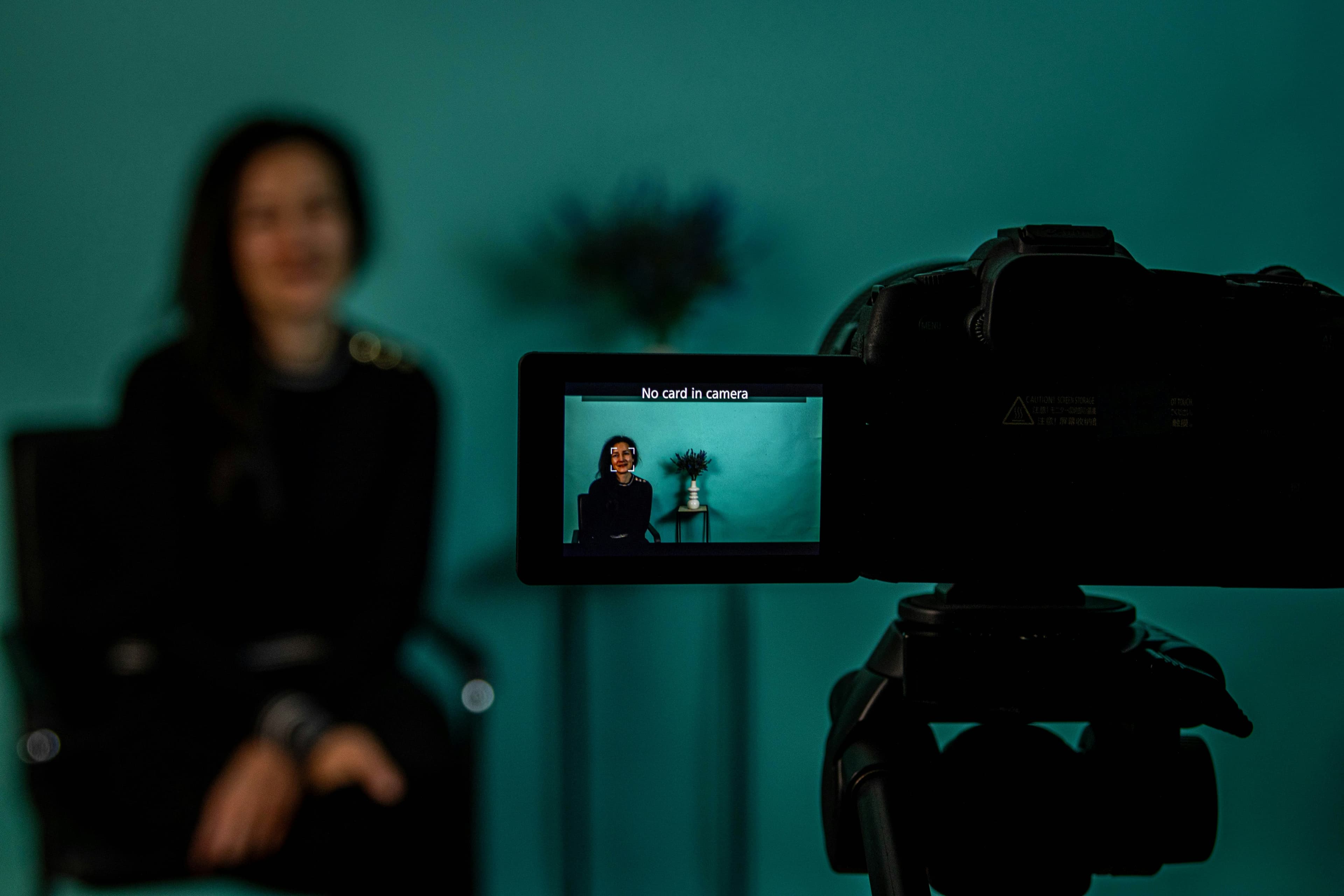 A creator filming video content with a camera and monitor in a modern production setup focused on content creation.
